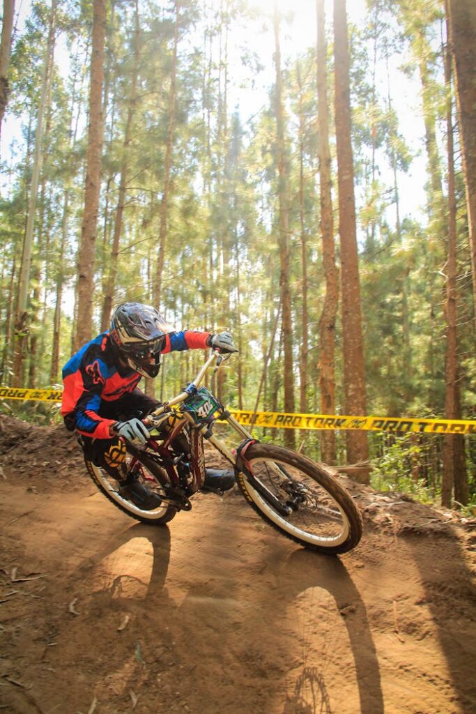 Dynamic shot of a mountain biker taking a sharp turn on a forest trail during a race.